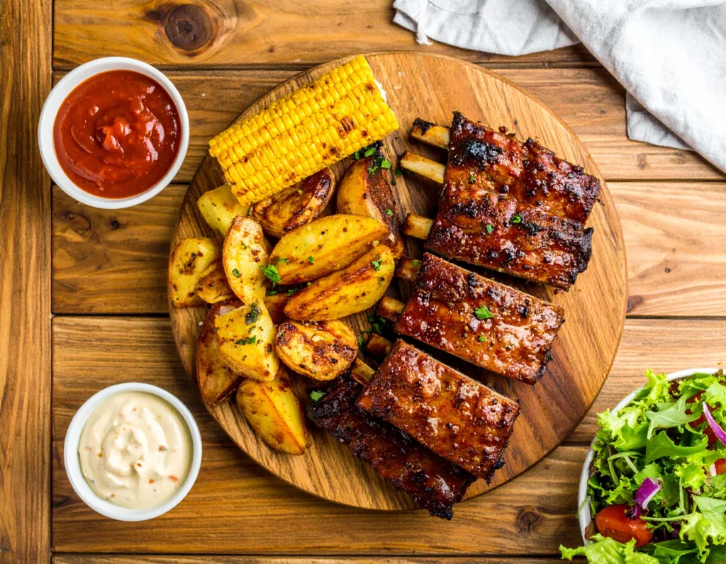 beef back ribs recipe served with barbecue sause on a wooden board
